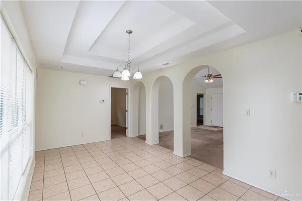 an empty room with fan and windows