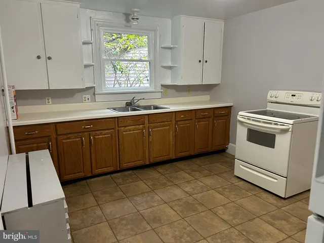 a kitchen with a stove sink and cabinets