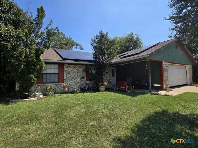a view of a house with a yard and tree s