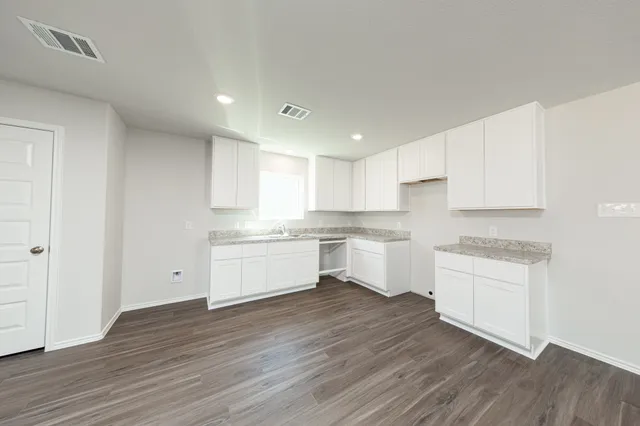 a kitchen with wooden floors and white appliances