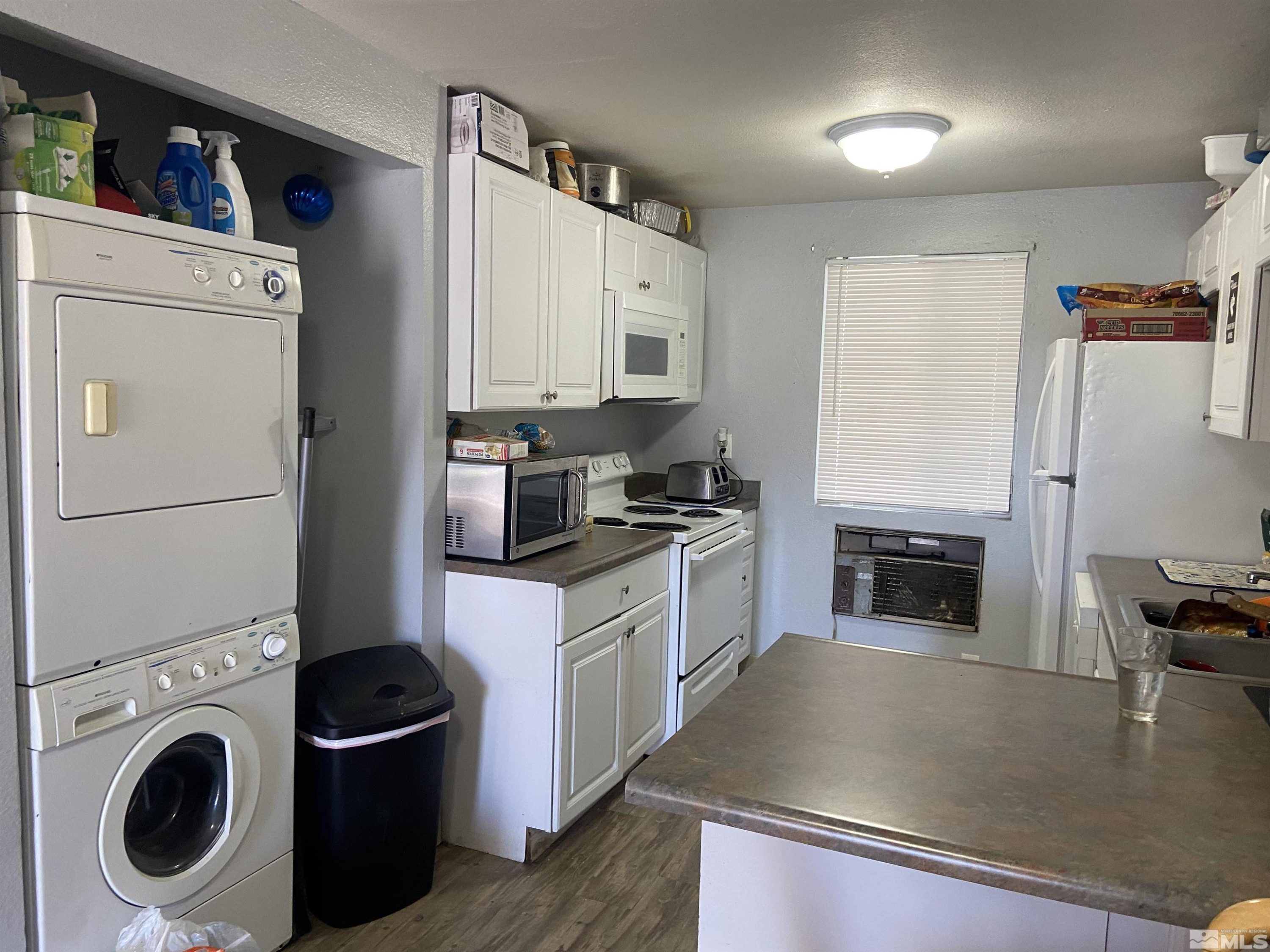 3589 Mazzone Avenue Reno, NV 89502 - Photo 6 of 12 a kitchen with stainless steel appliances granite countertop a refrigerator a stove and a sink with wooden floors