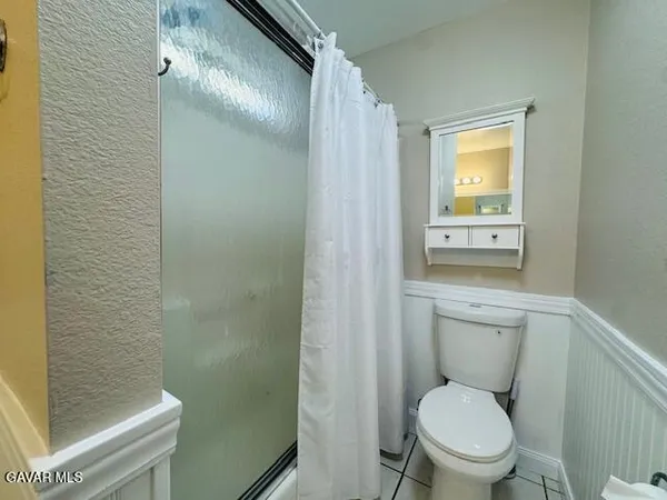 a white toilet sitting next to a shower curtain