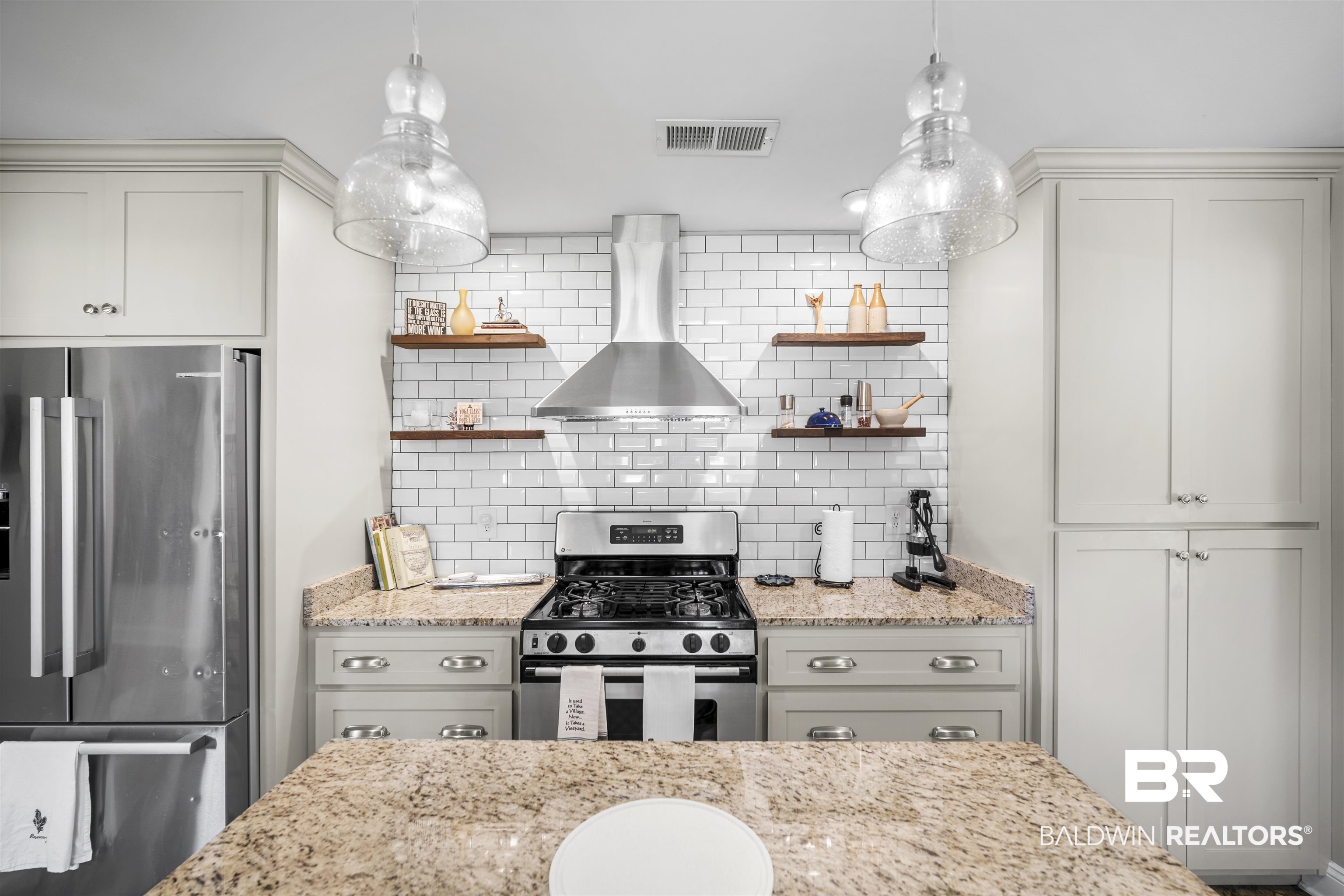 1615 5th Street Daphne, AL 36526 - Photo 8 of 28 Kitchen featuring a gas range, stainless steel appliances, a subway tile backsplash, open shelving, and granite countertops
