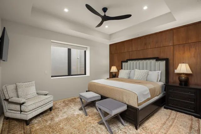 a bedroom with a bed a couch and a chandelier