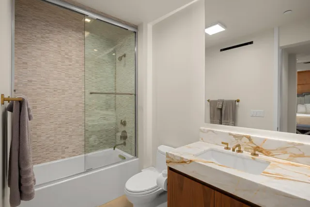 a bathroom with a granite countertop sink toilet and shower