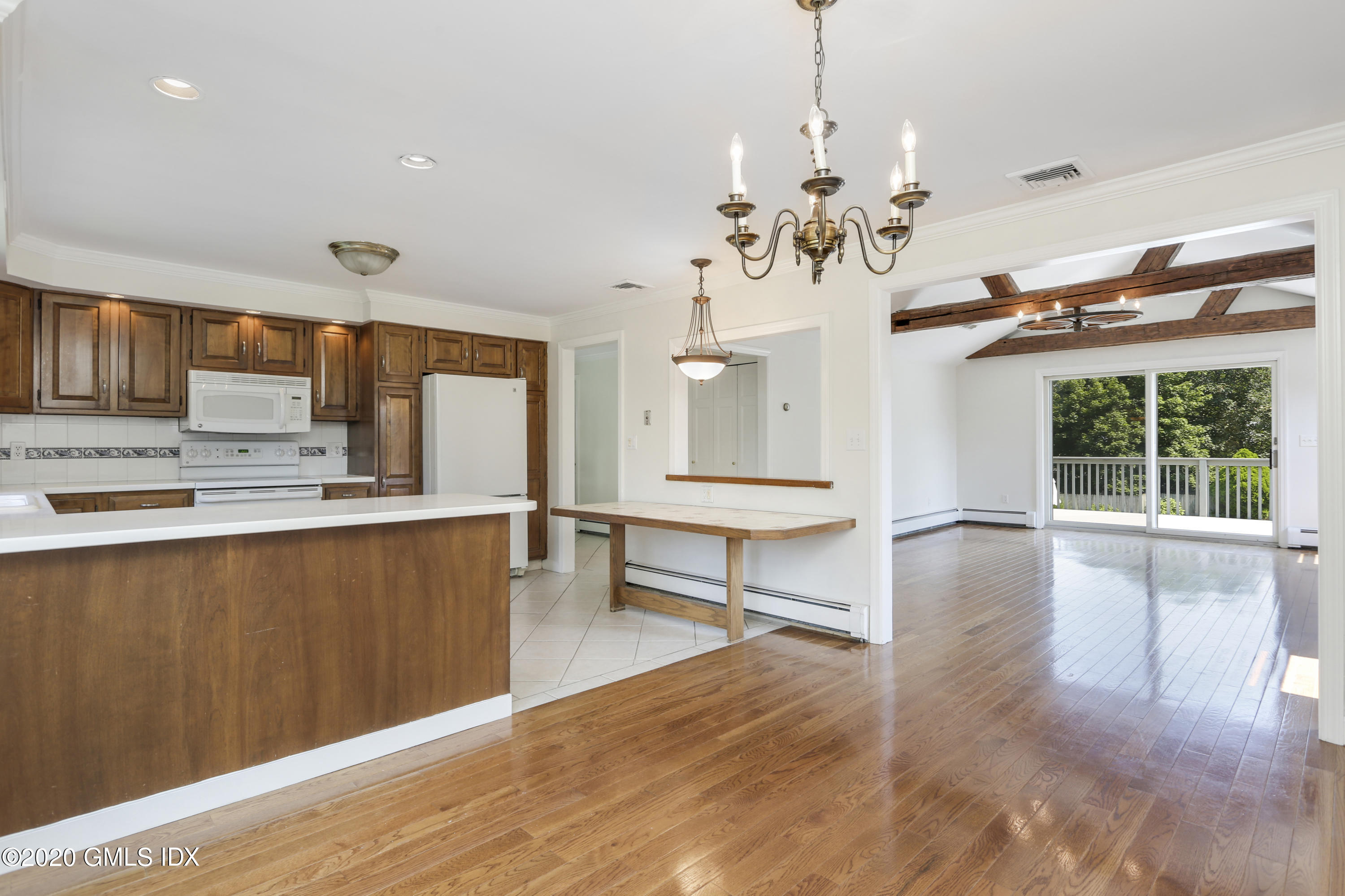 18 Norias Road Greenwich, CT 06830 - Photo 9 of 37 a view of a kitchen with furniture a chandelier and wooden floor