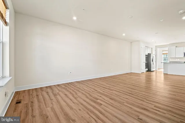 a view of empty room with wooden floor and windows