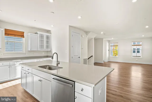 a kitchen with a sink cabinets and wooden floor