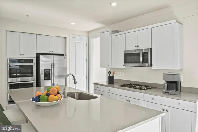 a kitchen with stainless steel appliances granite countertop a sink and a stove