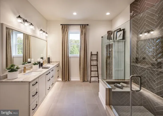 a bathroom with a double vanity sink a toilet a mirror and shower