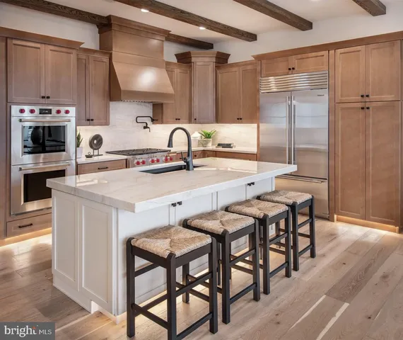 a kitchen with stainless steel appliances granite countertop a kitchen island a stove a table and chairs in it