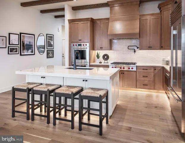 a kitchen with stainless steel appliances granite countertop table chairs sink and stove