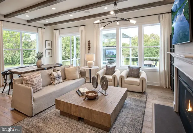 a living room with furniture large windows and a table