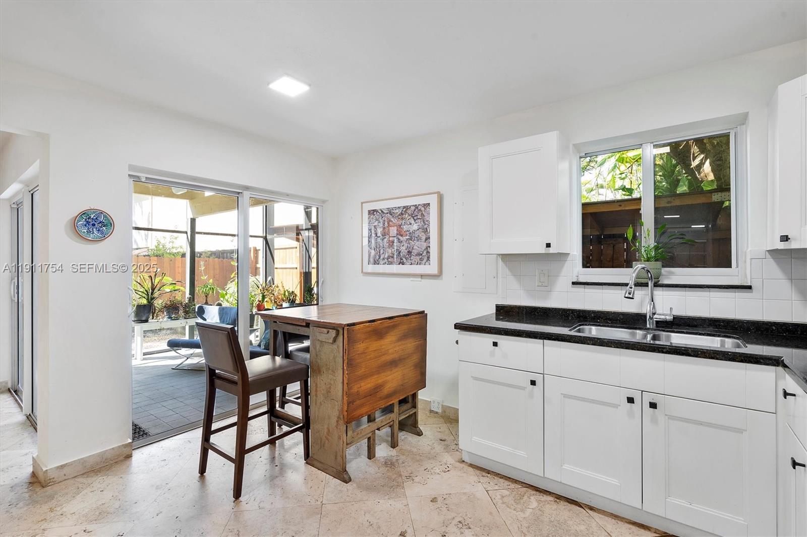 3235 McDonald Street, Unit 5 Miami, FL 33133 - Photo 13 of 35 a kitchen with granite countertop white cabinets and window