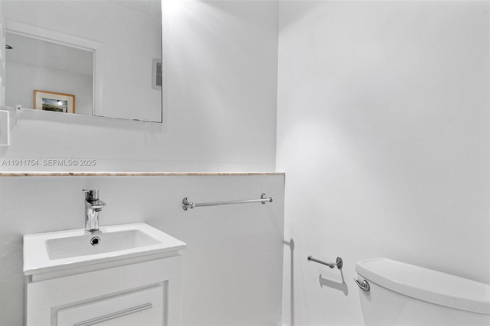 3235 McDonald Street, Unit 5 Miami, FL 33133 - Photo 22 of 35 a bathroom with a sink a toilet and mirror