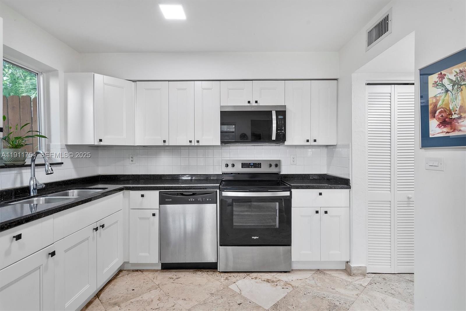 3235 McDonald Street, Unit 5 Miami, FL 33133 - Photo 10 of 35 a kitchen with stainless steel appliances granite countertop a stove a sink and a microwave