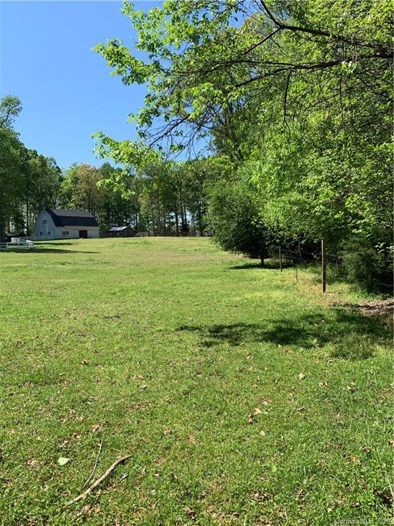 15015 Ranson Road Huntersville, NC 28078 - Photo 11 of 19 a view of a grassy field with trees in the background