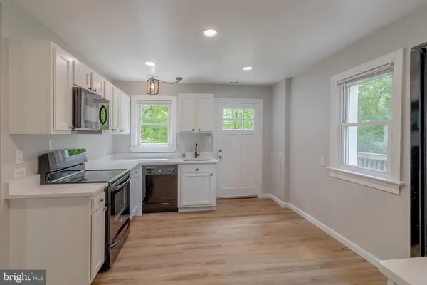 a kitchen with a sink cabinets appliances and a window