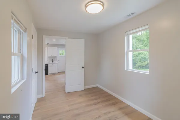 an empty room with windows and closet