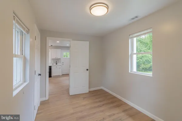 a view of a room with wooden floor and a bathroom
