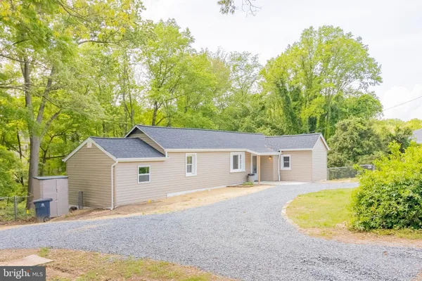 a aerial view of a house with swimming pool and trees all around