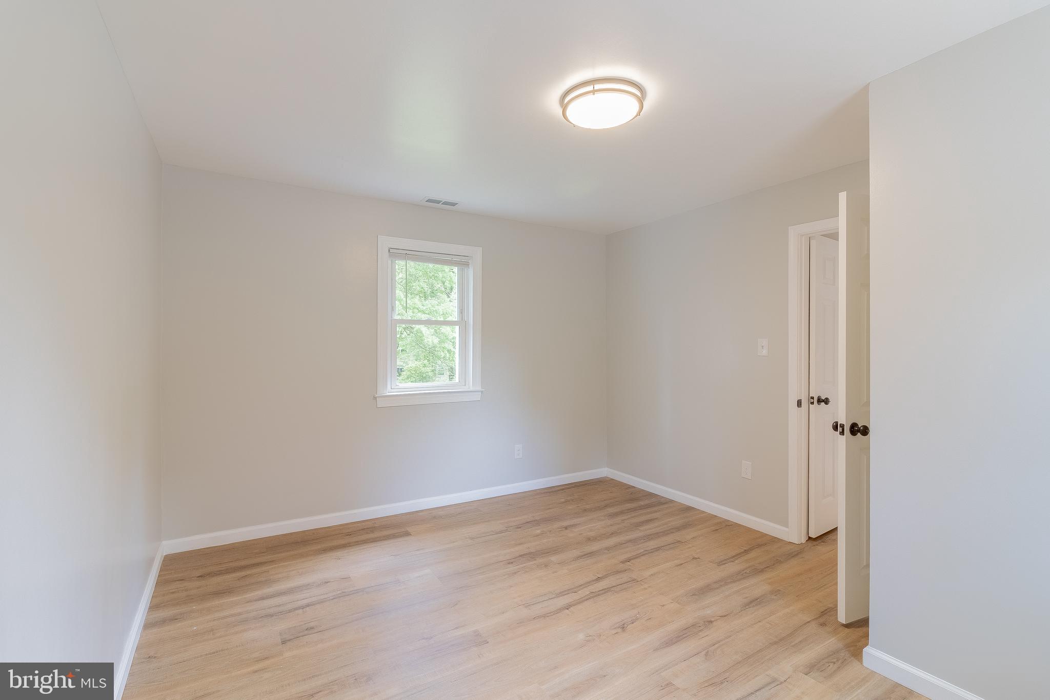 1816 Maple Lane Accokeek, MD 20607 - Photo 4 of 24 an empty room with wooden floor and windows