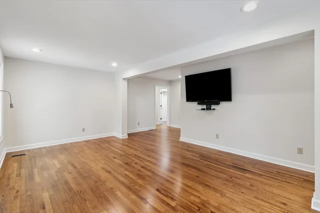a view of a livingroom with wooden floor and a flat screen tv