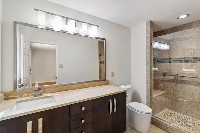 a bathroom with a double vanity sink toilet and shower