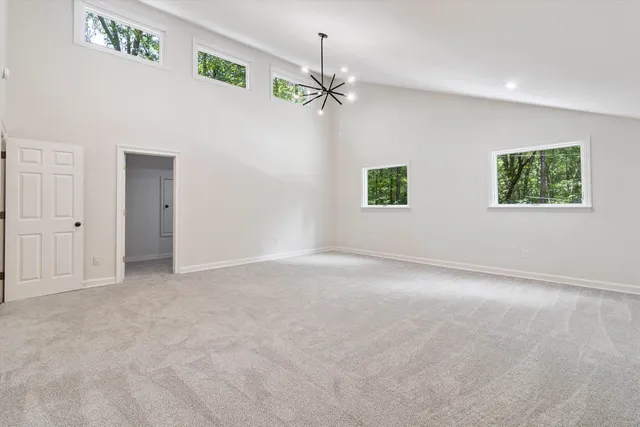 an empty room with windows and ceiling fan