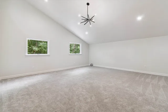 an empty room with windows and ceiling fan