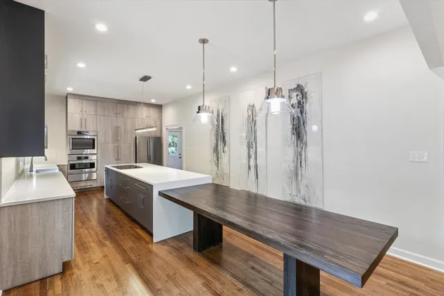 a kitchen with stainless steel appliances kitchen island a wooden floor