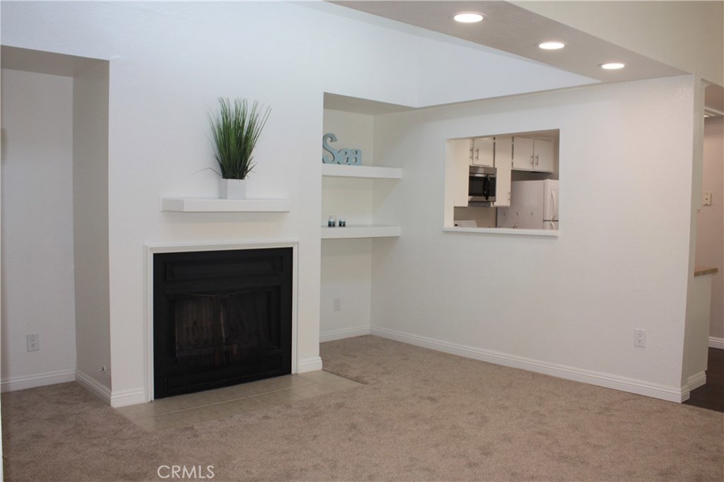 17041 A Lane, Unit B Huntington Beach, CA 92647 - Photo 1 of 16 a big room with windows and a fireplace