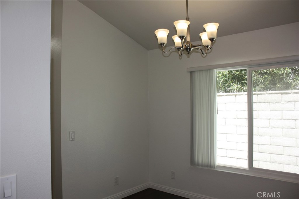 17041 A Lane, Unit B Huntington Beach, CA 92647 - Photo 3 of 16 a dining room with wooden floor chandelier and window