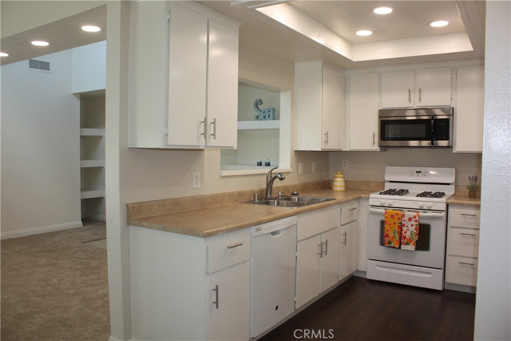 17041 A Lane, Unit B Huntington Beach, CA 92647 - Photo 5 of 16 a kitchen with a sink a stove and cabinets