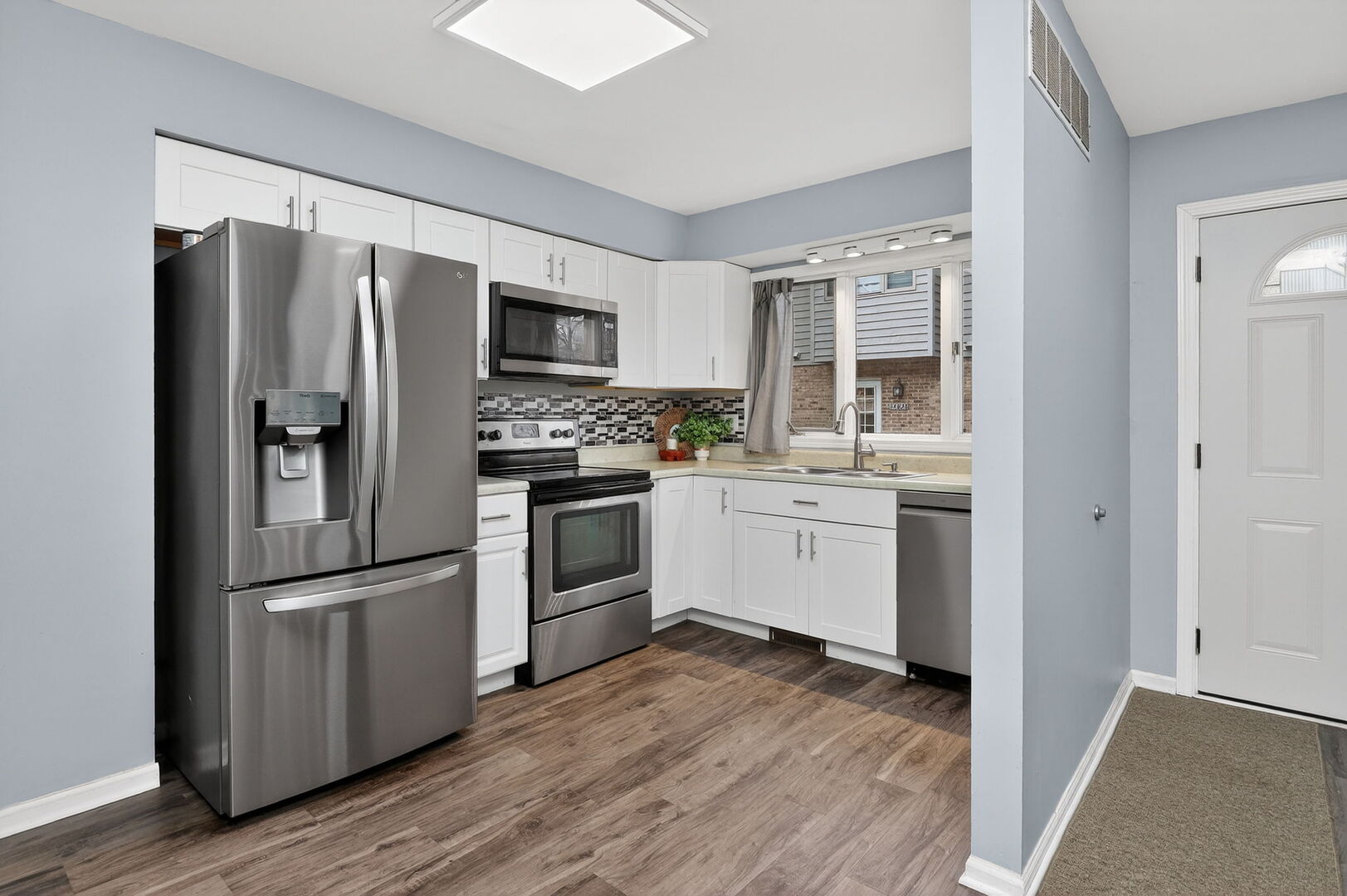 14816 South Penn Road Plainfield, IL 60544 - Photo 4 of 23 a kitchen with a refrigerator sink and wooden floor