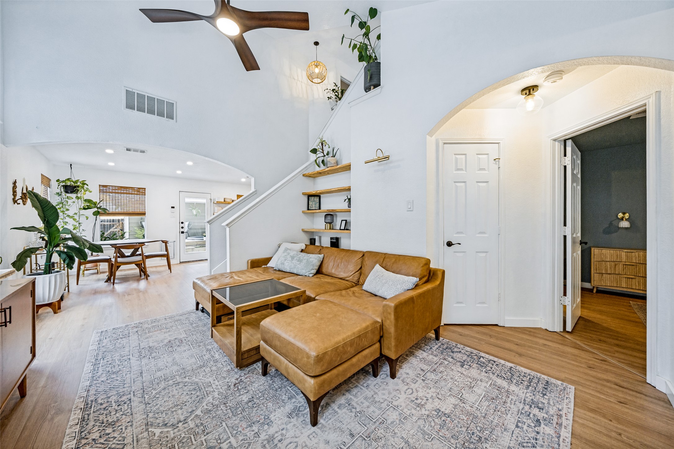 9205 Rowlands Sayle Road Austin, TX 78744 - Photo 5 of 25 Natural light illuminates this living space, featuring high ceilings and beautiful wood flooring.