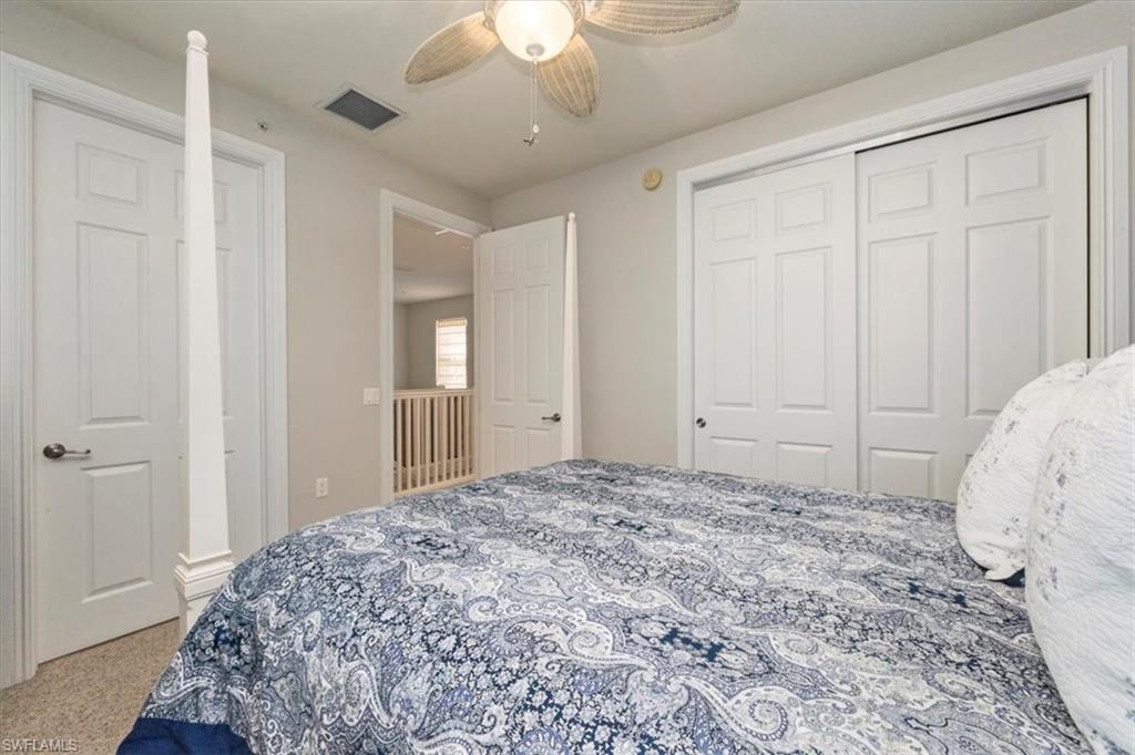 9105 Yuba Lane, Unit 7902 Naples, FL 34113 - Photo 20 of 25 a spacious bedroom with a bed and a chandelier