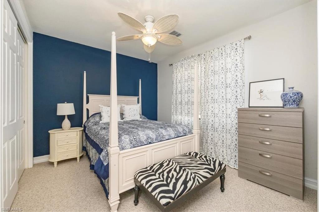 9105 Yuba Lane, Unit 7902 Naples, FL 34113 - Photo 21 of 25 a bedroom with a bed and a chandelier