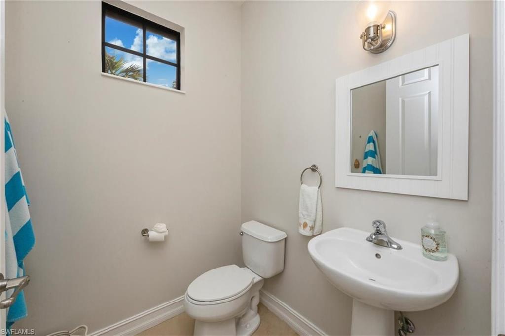 9105 Yuba Lane, Unit 7902 Naples, FL 34113 - Photo 23 of 25 a bathroom with a toilet sink and mirror