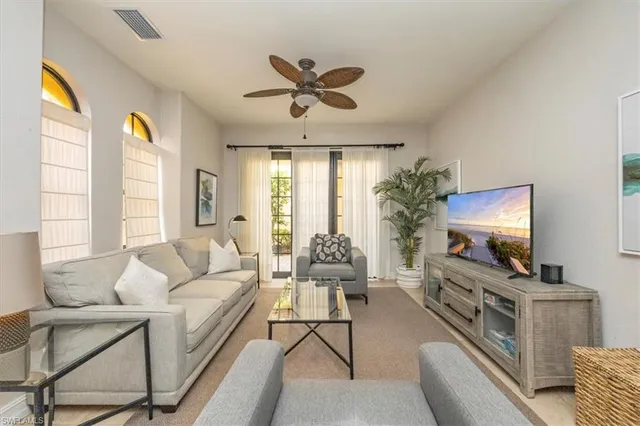 a living room with furniture a flat screen tv and a large window