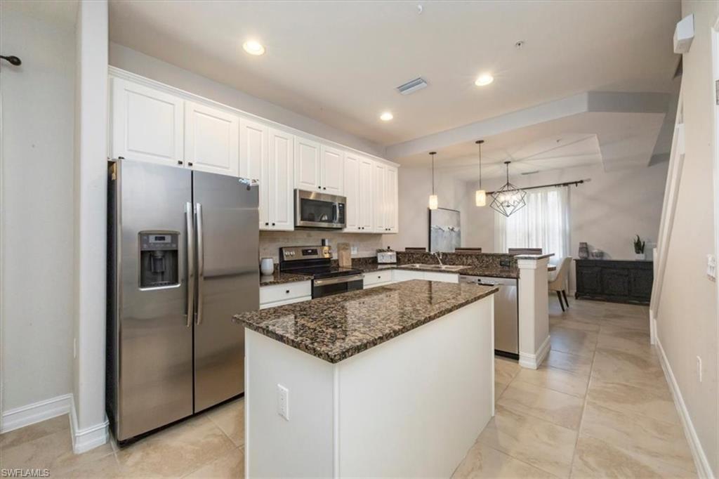 9105 Yuba Lane, Unit 7902 Naples, FL 34113 - Photo 10 of 25 a kitchen with a refrigerator a sink and cabinets