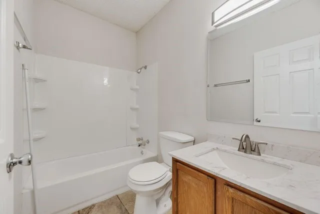 a bathroom with a granite countertop sink toilet and shower