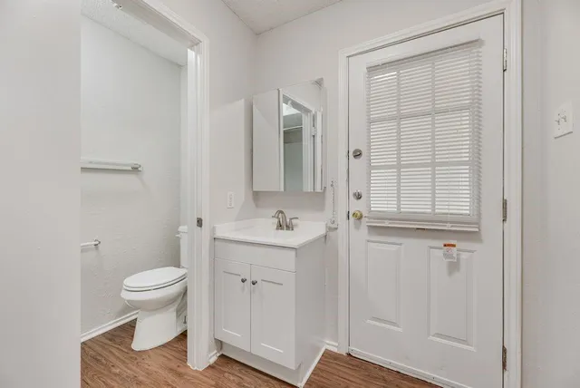 a bathroom with a granite countertop sink a toilet and a shower