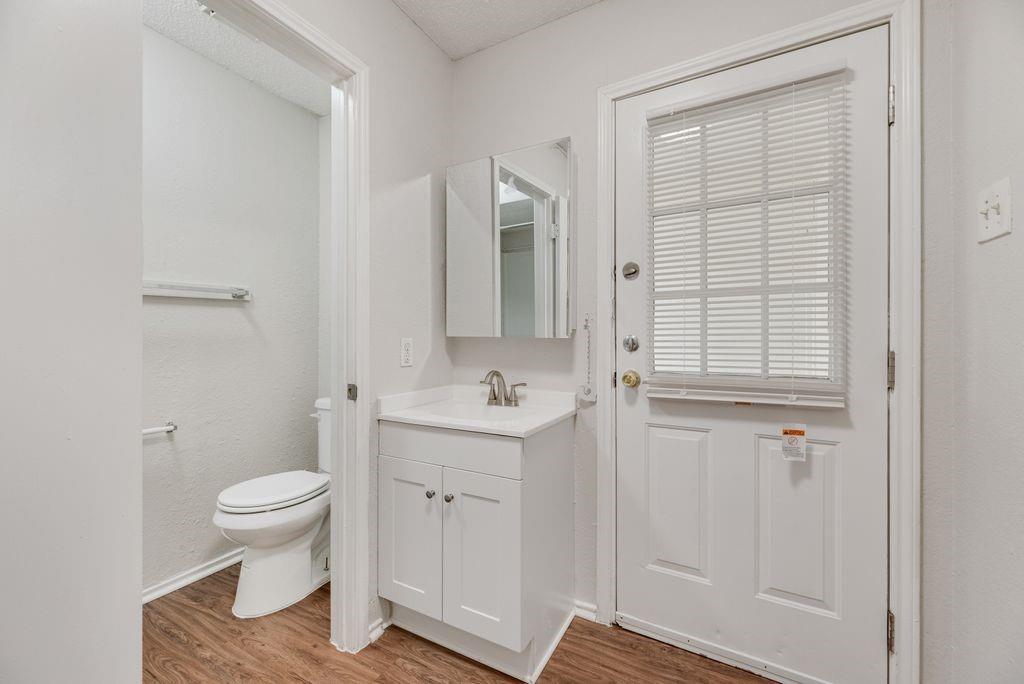 648 South Rogers Road, Unit 650 Irving, TX 75060 - Photo 17 of 21 a bathroom with a granite countertop sink a toilet and a shower