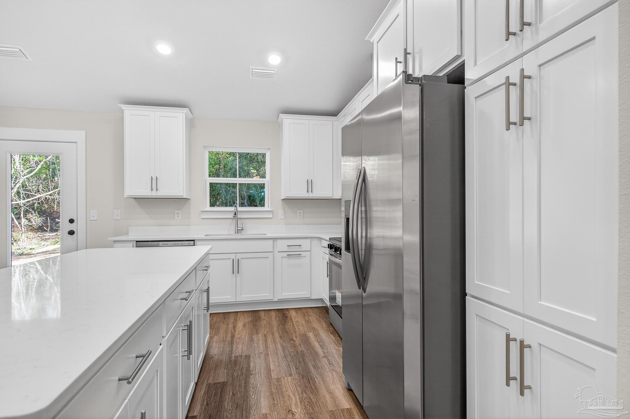 1056 Barth Road Molino, FL 32577 - Photo 36 of 46 a kitchen with a refrigerator a sink and cabinets
