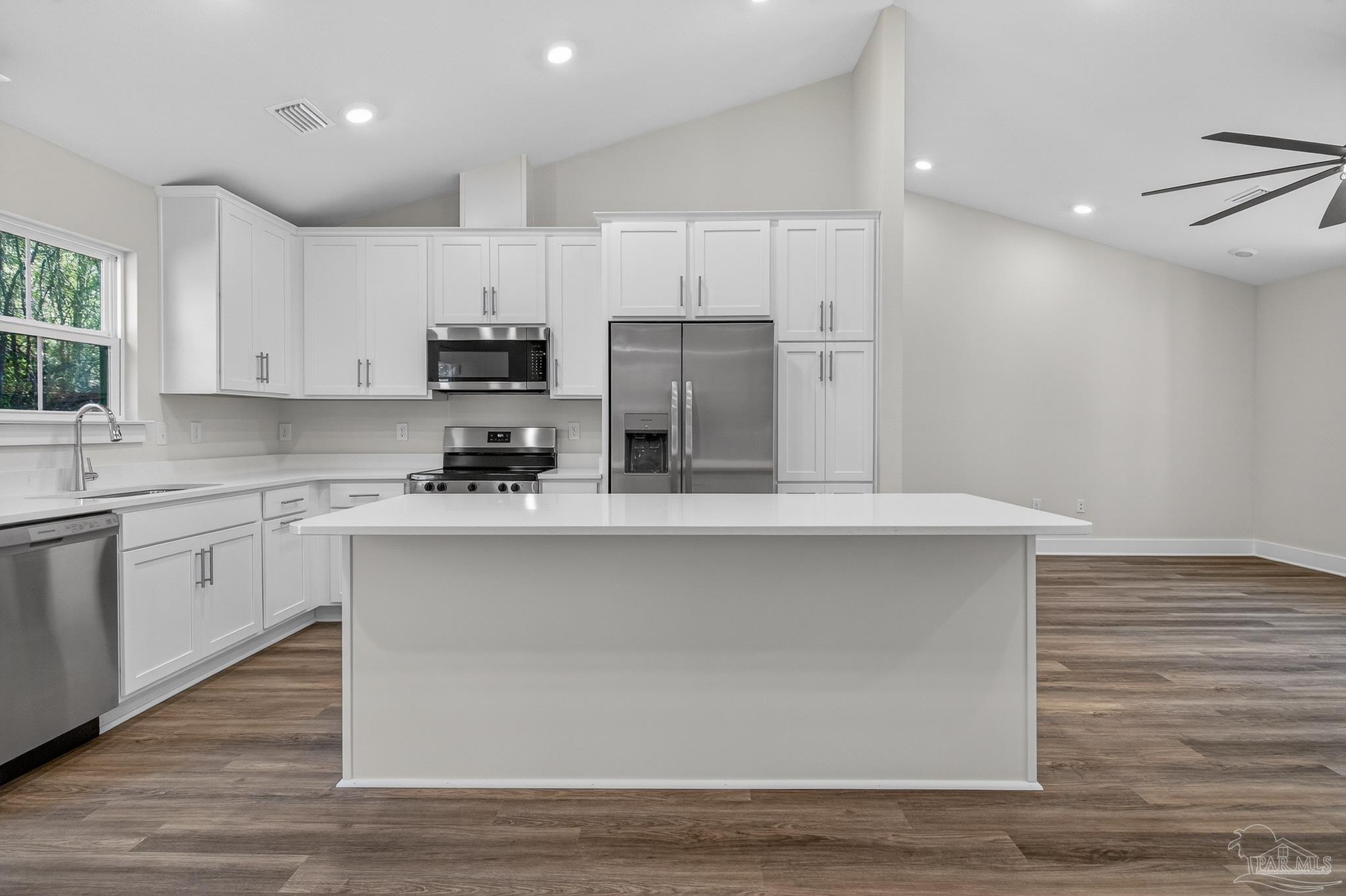 1056 Barth Road Molino, FL 32577 - Photo 9 of 46 a kitchen with kitchen island white cabinets and stainless steel appliances