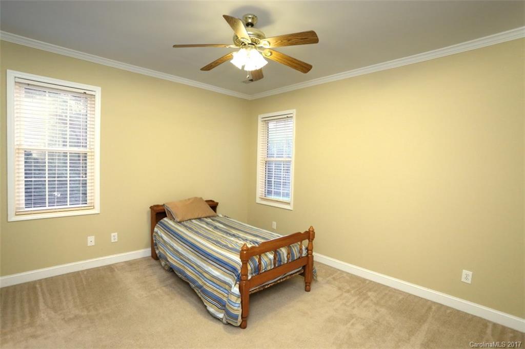 9805 Vineyard Road Mount Pleasant, NC 28124 - Photo 15 of 24 a spacious bedroom with a bed and a chandelier