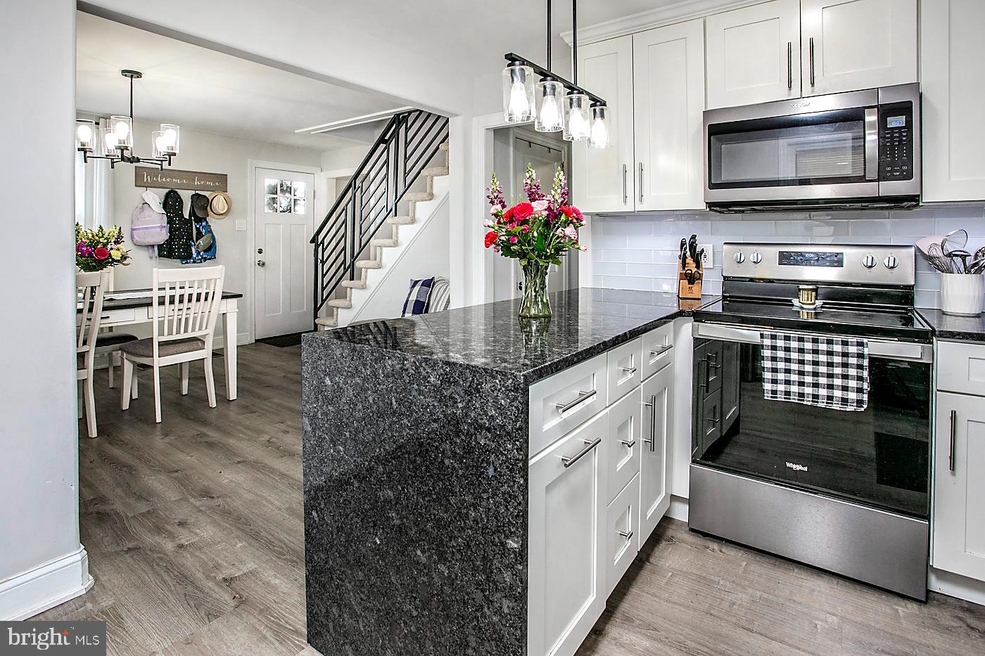 2817 Egypt Road Audubon, PA 19403 - Photo 7 of 25 a kitchen with stainless steel appliances kitchen island granite countertop a stove a sink and a microwave
