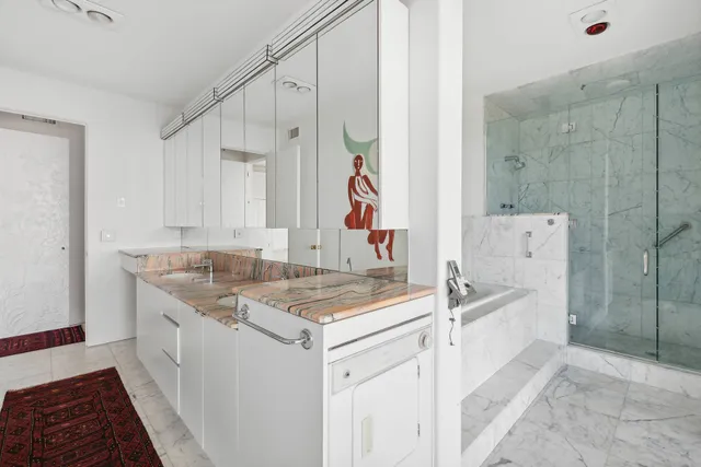 a bathroom with a granite countertop sink a toilet a shower and a mirror