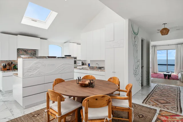 a kitchen with stainless steel appliances granite countertop a table chairs and a refrigerator